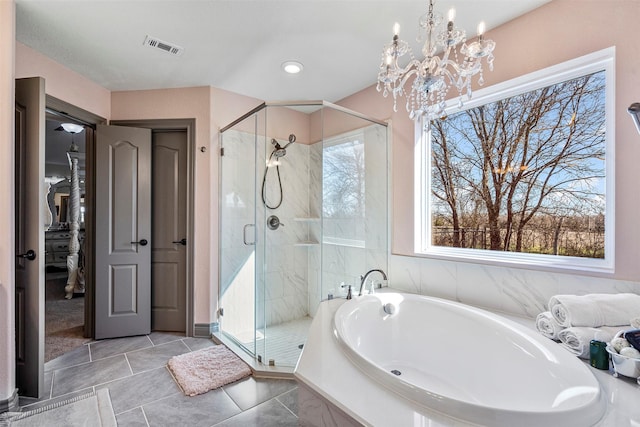 full bathroom with a wealth of natural light, a garden tub, visible vents, and a shower stall