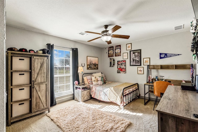 bedroom with light carpet, ceiling fan, a textured ceiling, and visible vents