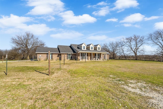 view of front facade with a porch, a front yard, and brick siding