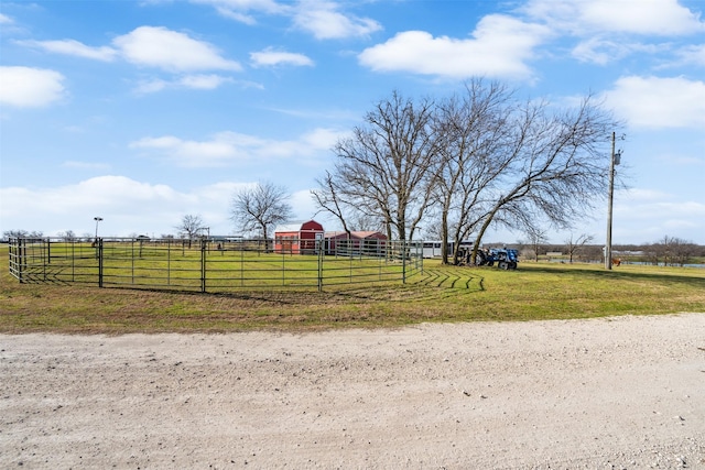 view of yard featuring a rural view, an outdoor structure, and fence