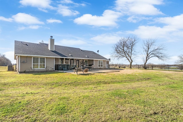 rear view of property with a patio area, a jacuzzi, a lawn, and fence