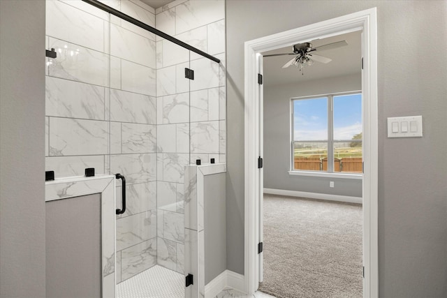 full bath with ceiling fan, a stall shower, and baseboards