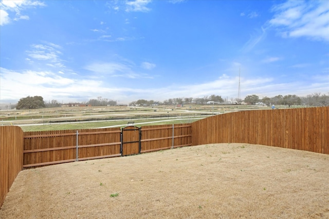 view of yard with a rural view and fence