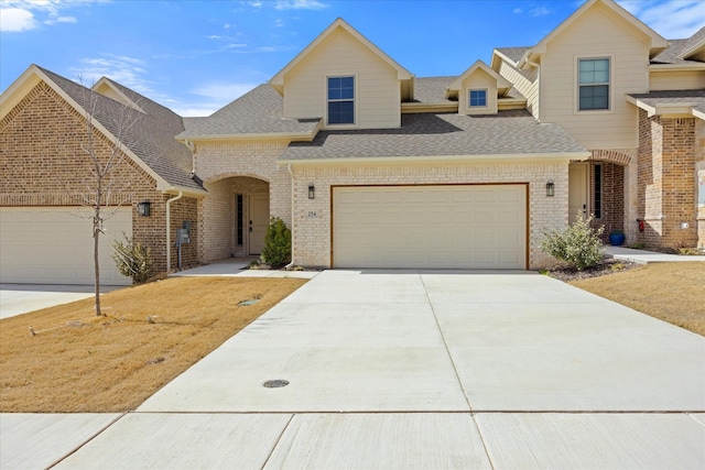 view of front of property with brick siding, driveway, and an attached garage