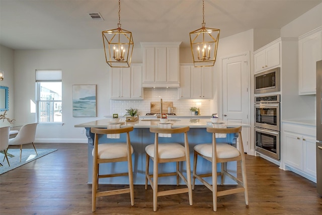 kitchen featuring a chandelier, backsplash, visible vents, and appliances with stainless steel finishes