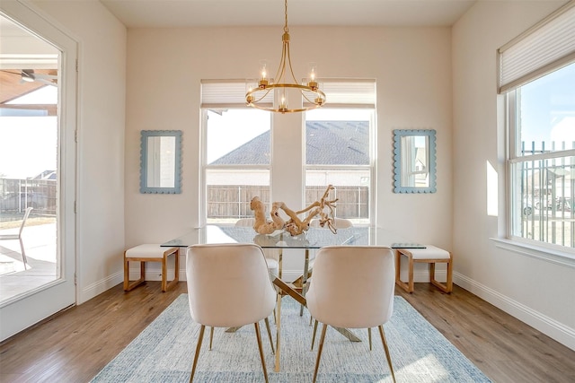 dining area with baseboards, a chandelier, and wood finished floors