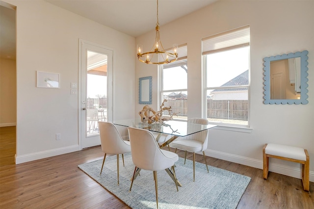 dining room featuring plenty of natural light, a notable chandelier, and wood finished floors