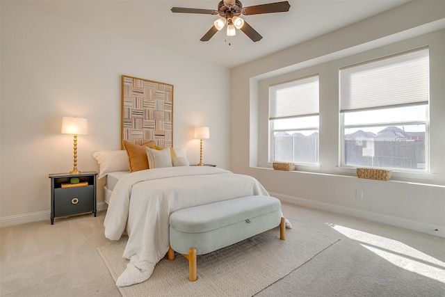 bedroom with light carpet, a ceiling fan, and baseboards