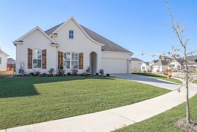 french country home featuring a garage, a shingled roof, brick siding, driveway, and a front lawn