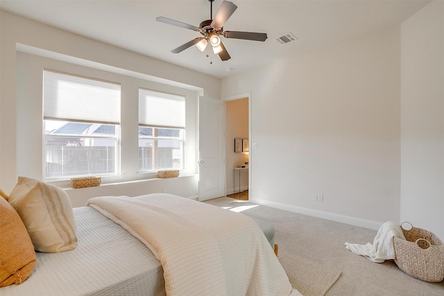 carpeted bedroom featuring ceiling fan, visible vents, and baseboards