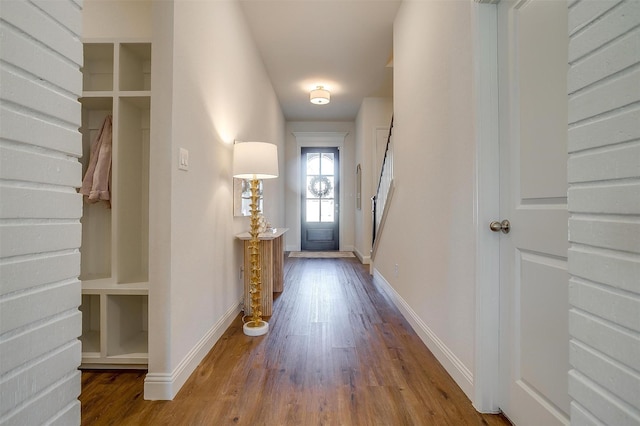 doorway with wood finished floors and baseboards