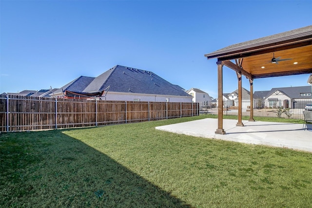 view of yard featuring a ceiling fan, a residential view, a fenced backyard, and a patio