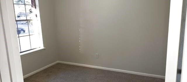 spare room featuring carpet flooring and baseboards