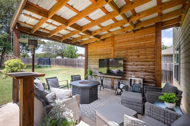 view of patio featuring a fenced backyard, a trampoline, and a fire pit