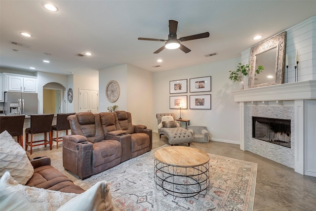 living room with visible vents, arched walkways, and recessed lighting