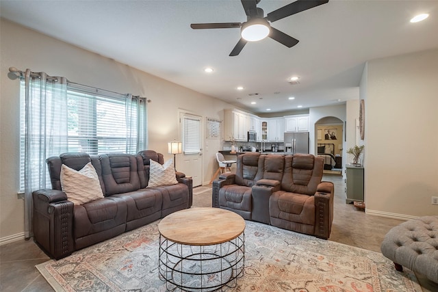 living area featuring arched walkways, baseboards, and recessed lighting