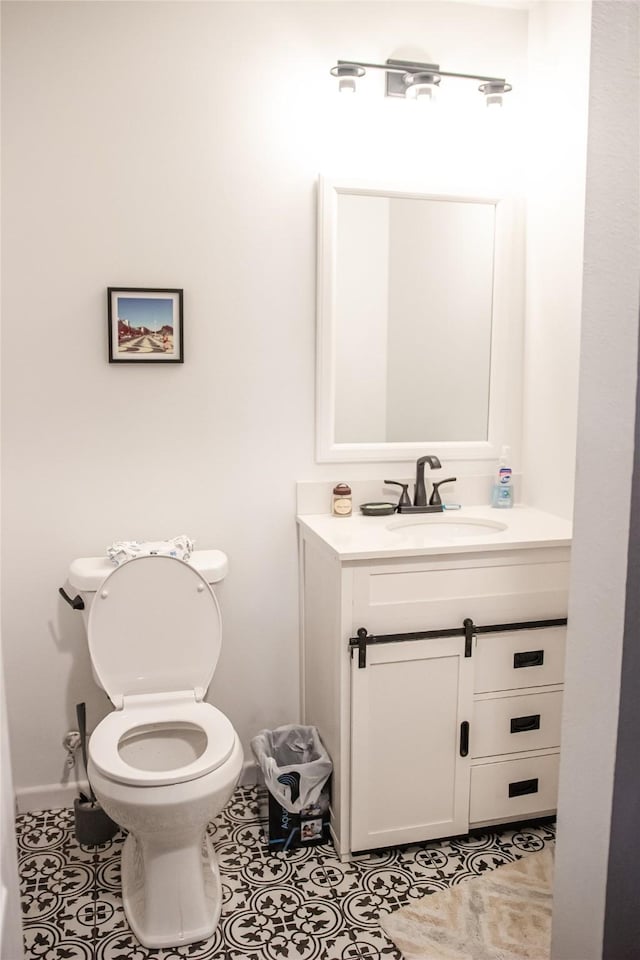 half bathroom with tile patterned flooring, vanity, and toilet