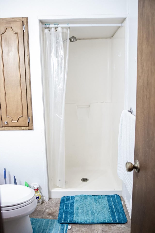 full bath with a shower stall, toilet, and tile patterned floors