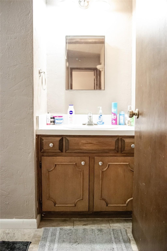 bathroom with a textured wall and vanity