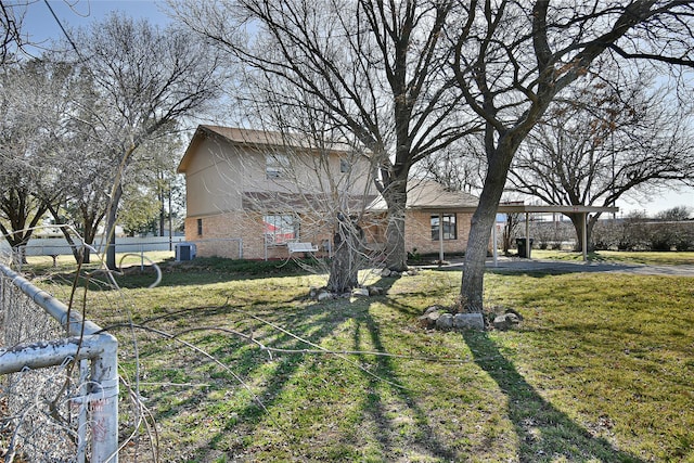 view of front facade featuring central air condition unit, a front yard, fence, and brick siding