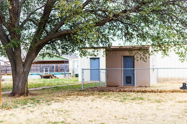 rear view of house with a fenced in pool, an outbuilding, and a fenced backyard