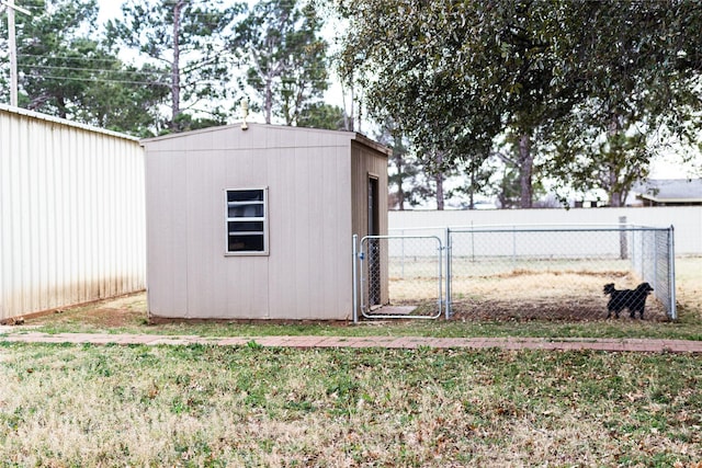 view of shed featuring fence and a gate