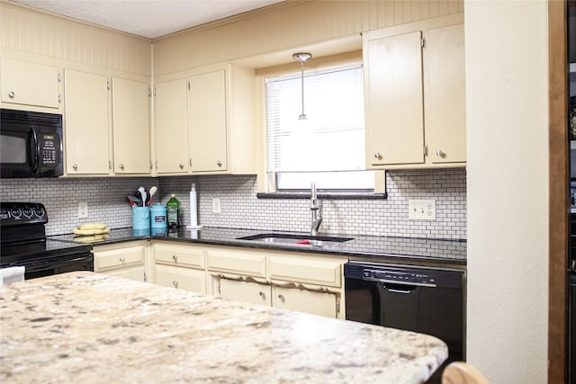 kitchen with black appliances, pendant lighting, decorative backsplash, and a sink