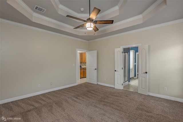 unfurnished bedroom with light carpet, visible vents, baseboards, ornamental molding, and a raised ceiling