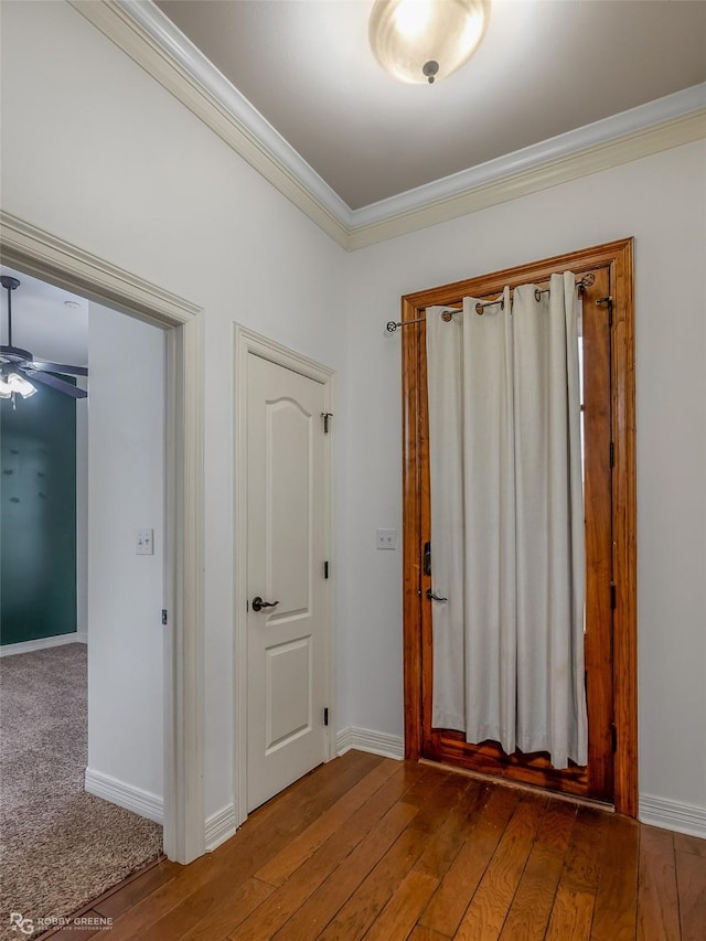 foyer entrance with hardwood / wood-style flooring, baseboards, and crown molding