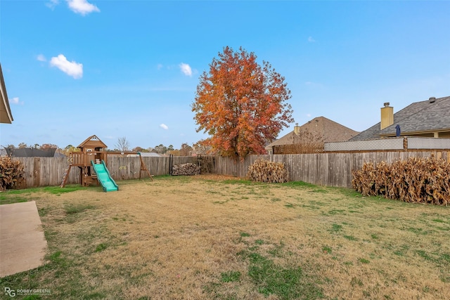 view of yard featuring a playground and a fenced backyard