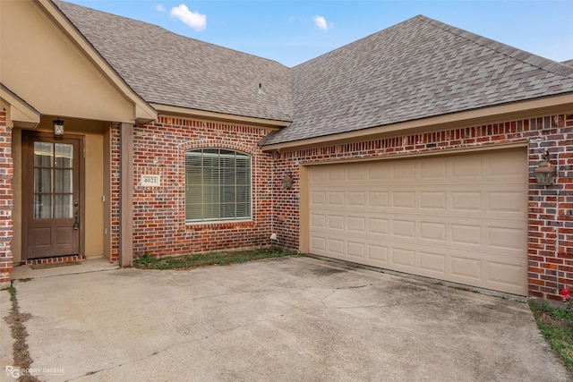 exterior space with a garage, driveway, a shingled roof, and brick siding