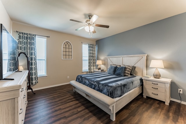 bedroom with dark wood-type flooring, multiple windows, a ceiling fan, and baseboards