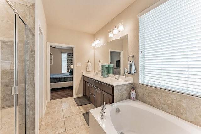 full bath featuring double vanity, ensuite bathroom, a sink, a bath, and tile patterned floors