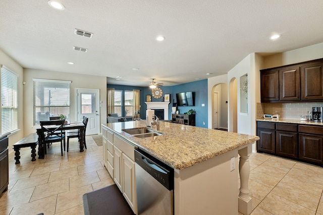 kitchen with a fireplace, visible vents, a sink, and stainless steel dishwasher