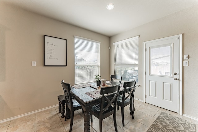 dining space with light tile patterned flooring and baseboards