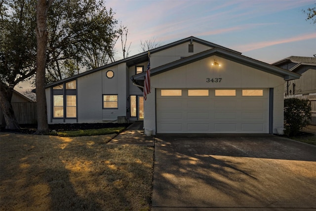 mid-century modern home with brick siding, driveway, and a garage