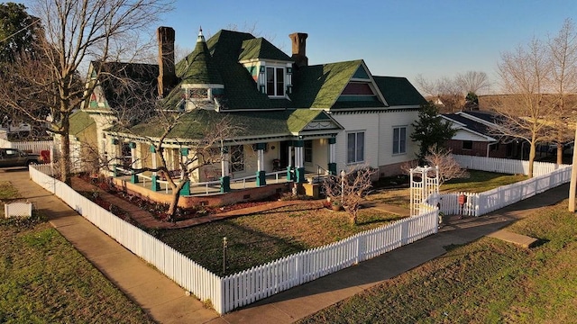 view of front of property with a front lawn, covered porch, a fenced front yard, and crawl space