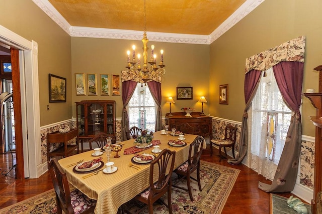 dining area with a wainscoted wall, wood finished floors, a chandelier, and ornamental molding