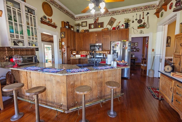 kitchen featuring a sink, backsplash, crown molding, stainless steel appliances, and dark wood-style flooring