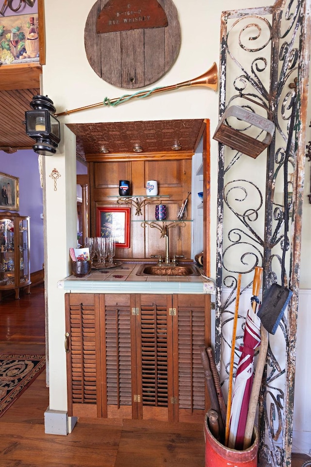 bar with a sink, wet bar, and wood finished floors