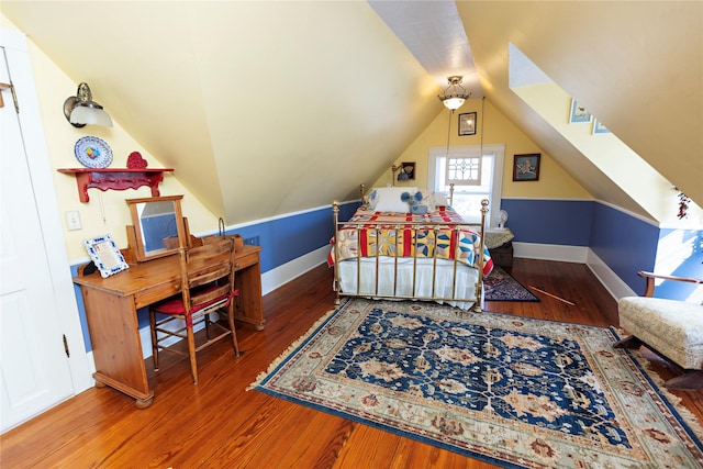 bedroom featuring baseboards, lofted ceiling, and wood finished floors