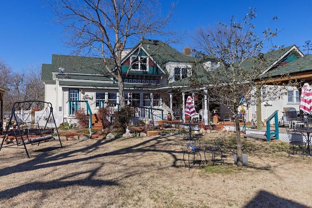 view of front facade with covered porch and a chimney