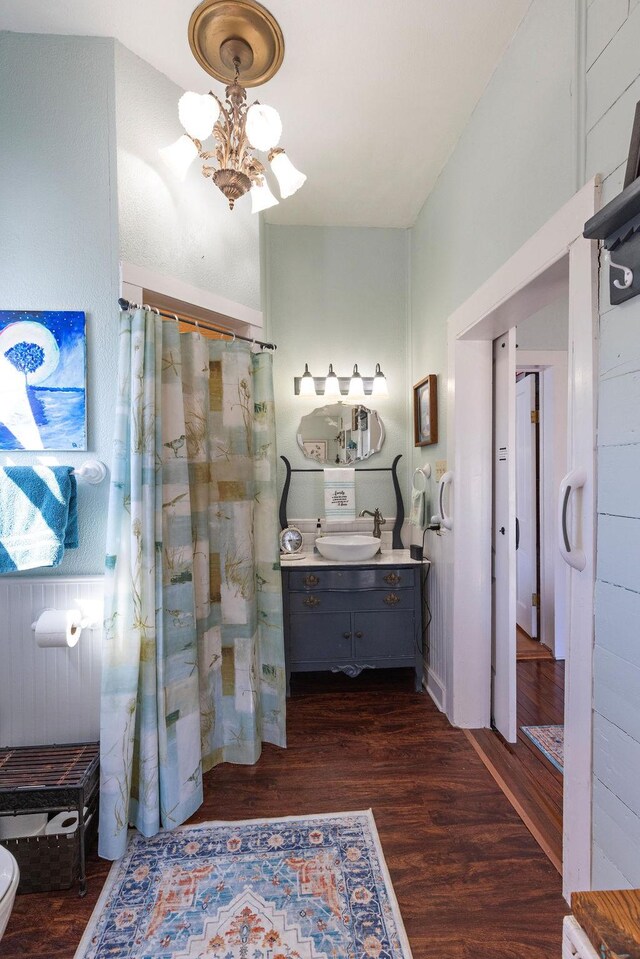 full bathroom featuring curtained shower, vanity, an inviting chandelier, and wood finished floors