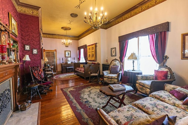 living area featuring a fireplace with flush hearth, ornamental molding, wood-type flooring, and a chandelier