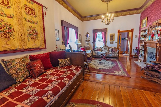 living room featuring a chandelier, a fireplace, hardwood / wood-style flooring, and ornamental molding