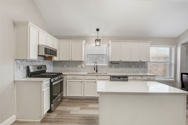 kitchen featuring a wealth of natural light, appliances with stainless steel finishes, lofted ceiling, and a sink