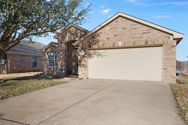 single story home with concrete driveway, an attached garage, and brick siding