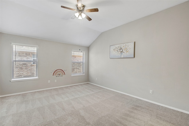 empty room with baseboards, carpet flooring, a ceiling fan, and lofted ceiling