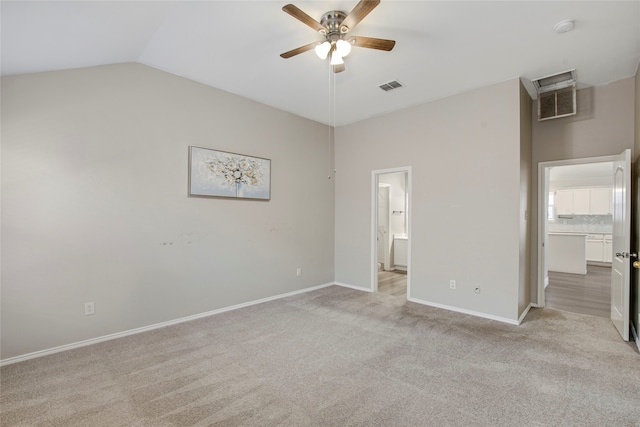 unfurnished bedroom featuring visible vents, light carpet, baseboards, and vaulted ceiling