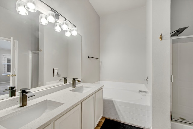 full bath with a sink, a garden tub, and a stall shower